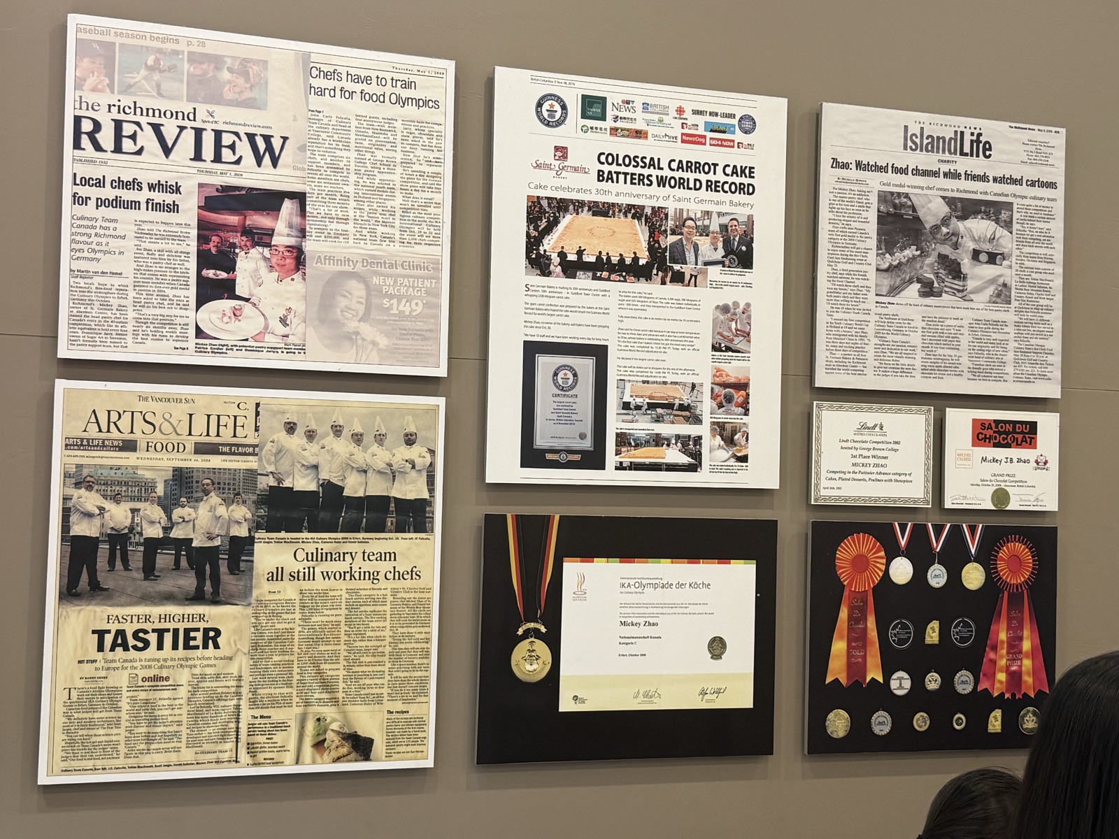 Wall of framed press features, a Guinness World Record certificate and competition medals